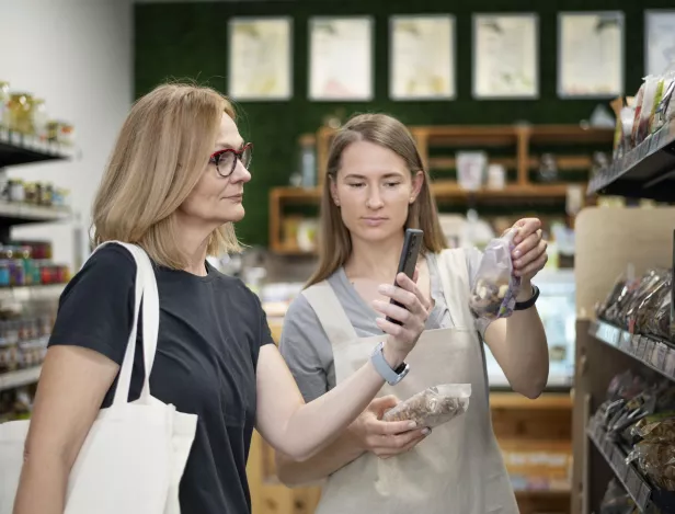 medium-shot-woman-checking-product-with-phone