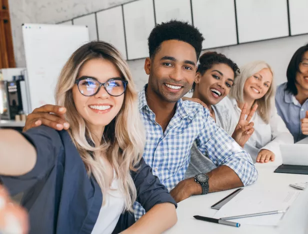 black-office-worker-checkered-shirt-embracing-blonde-secretary-woman-while-she-making-selfie-young-managers-international-company-having-fun-meeting